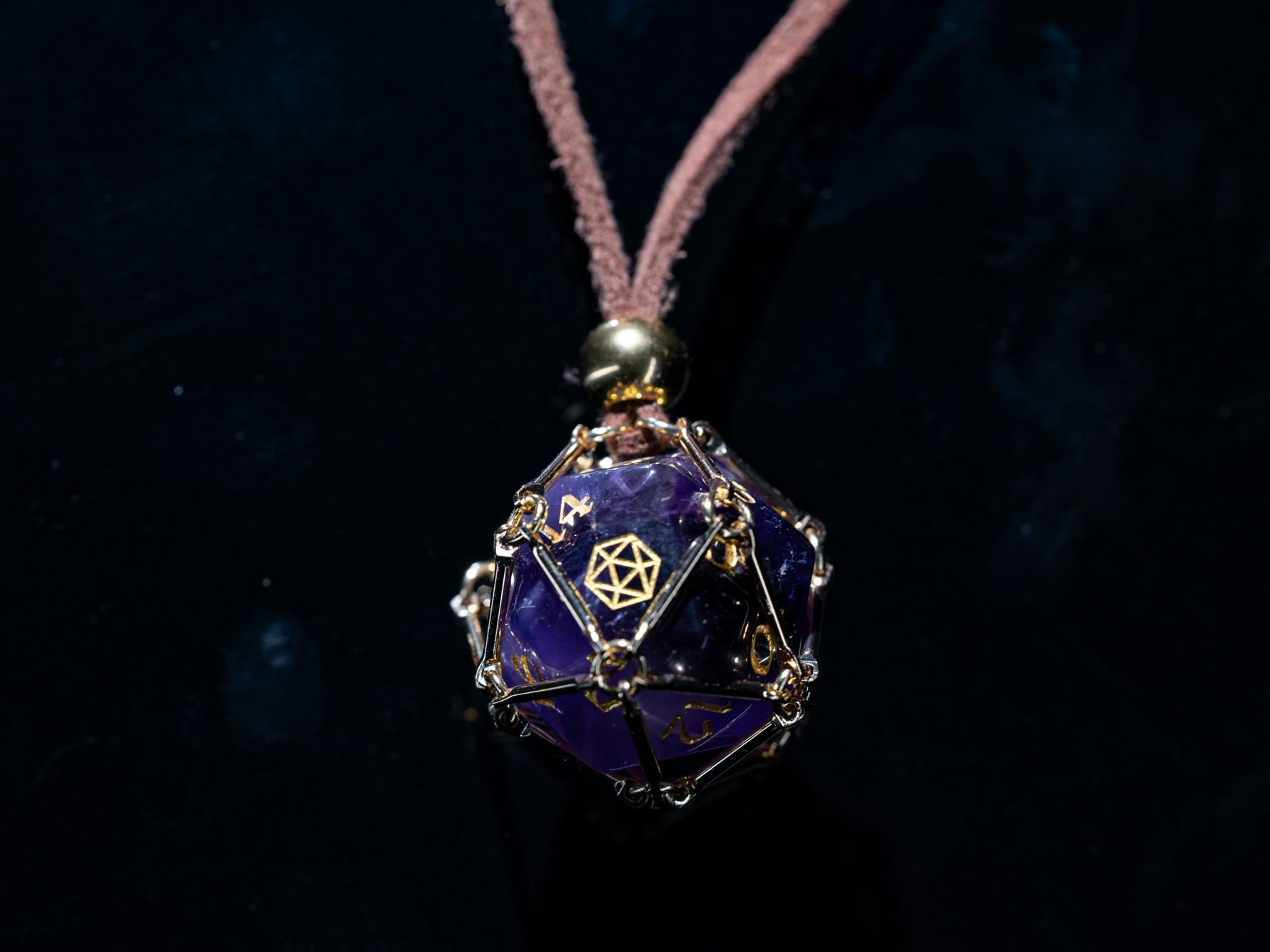 Angled macro shot of “Saga – Arcane Focus”: purple Amethyst D20 inside a golden dice cage on a brown PU leather necklace.